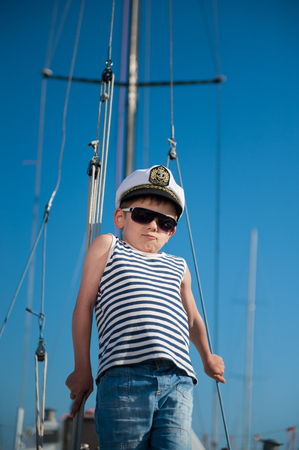 cool handsome little kid captain aboard luxury yachtの写真素材
