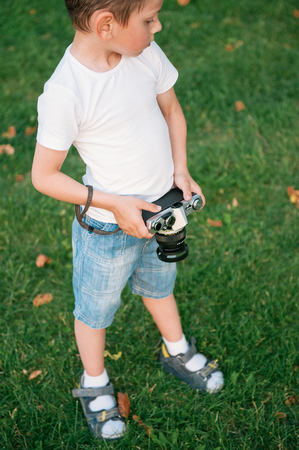 cute little boy holding film cameraの写真素材