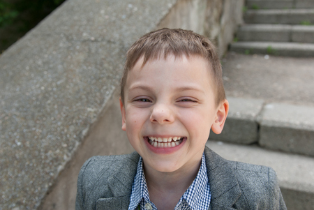 little laughing boy wearing a shirt and a jacketの写真素材