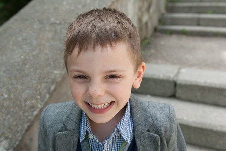 little smiling boy wearing a shirt and a jacketの写真素材