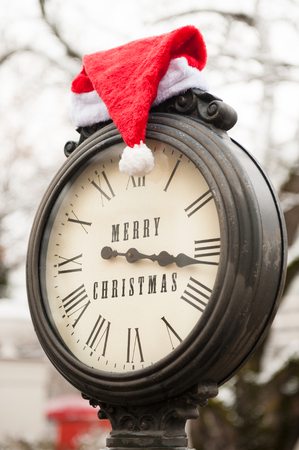 old clock with santa hat and words Merry Christmasの写真素材