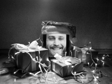 digital tablet with cute bearded male on screen and santa cap on it with Christmas attributes aroundの写真素材
