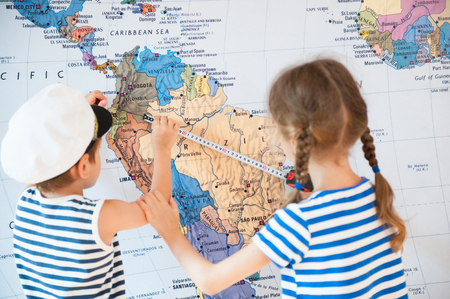 Boy and girl in sailor t-shirts measure the distance on the mapの写真素材