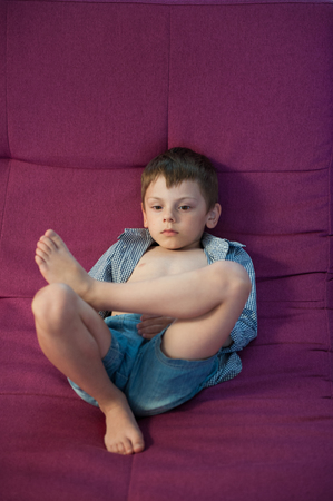slacker little kid lying on couch restingの写真素材