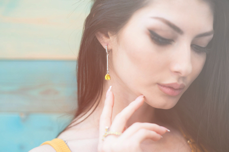 closeup portrait of beautiful young caucasian woman with closed eyes with earring and ringの写真素材