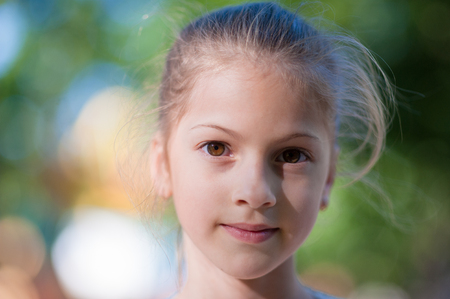 closeup portrait of beautiful little girl on colorful bokeh backgroundの写真素材