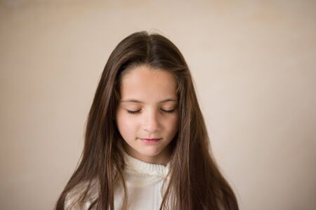happy meditative relax small kid girl with closed eyes wearing white sweaterの写真素材