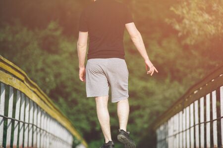sport active man walking on wood bridge during outdoor training in summerの写真素材