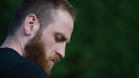 one person caucasian young bearded pensive mindful man on green background with coypy spaceの写真素材
