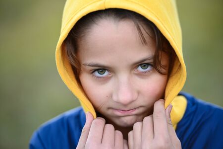 closeup portrait of frozen little thin girl in yellow and blue hoodie freeze on cold outdoor weather with health dangerの写真素材
