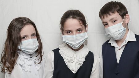 coronavirus covid-19 epidemic outbreak health care concept of family kids in school uniform wearing medical masksの写真素材