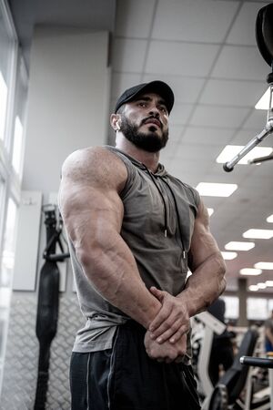 athletic physique concept of strong young man with beard in gymの写真素材