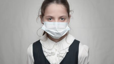 coronavirus covid-19 epidemic outbreak health care concept of young sick little kid wearing medical mask and school uniformの写真素材