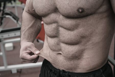 body fat weight loss sport nutrition concept on strong young man with perfect bodyの写真素材