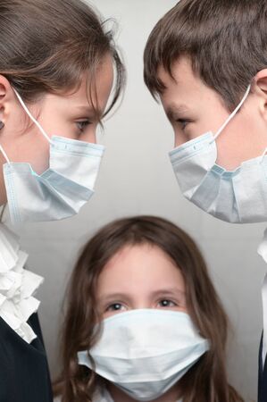 covid-19 transmission contact between people concept of three family children in medical mask together during coronavirus quarantineの写真素材