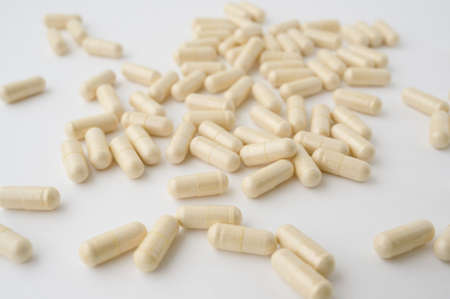 pharmacy drug capsules of vitamin medication on white tableの写真素材