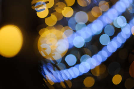 beautiful bright yellow and blue garland light during merry christmas eve night on city street with copy spaceの写真素材