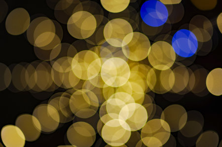 beautiful yellow and blue garland light blur bokeh color wheel ring background for merry christmas holiday eve backgroundの写真素材