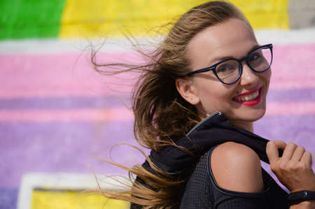 beautiful yount sport and active healthy pretty woman in fashion glasses on vivid color background outdoors leisure activityの写真素材