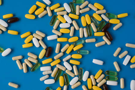 top view of many pills tablets gel and capsules of medicine pharmacy on blue surfaceの写真素材