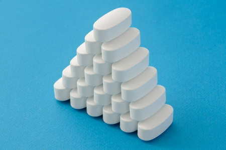 many pharmacological white tablets drugs pills on blue background with copy spaceの写真素材