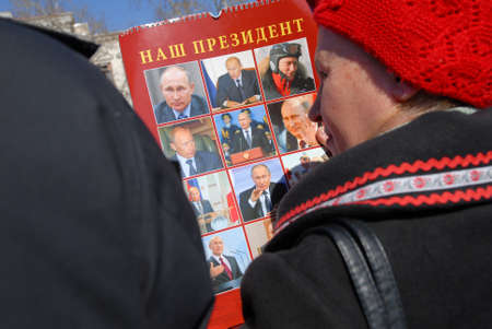 woman in red hat holding Vladimir Putin portrait during support meeting rally in Sevastopol, Crimea 29 Jan 2022のeditorial素材