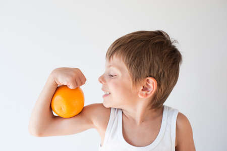 healthy little kid smiling wants to eat orangeの写真素材