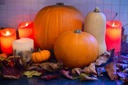 Warm Autumn Still Life with Pumpkins, Candles and Leaves Indoorsの写真素材