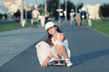 teenage girl riding a skateboard on the evening street