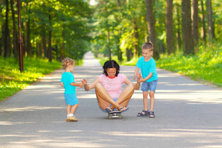 Family fun with skateboard. Little kids ride on a skateboard momの写真素材