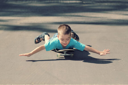 little boy with skateboard. little boy having fun with skateboard outdoors. little boy riding on his...