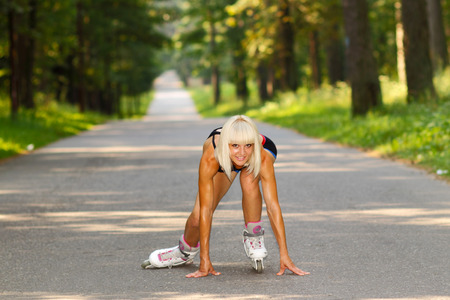 Young woman on roller skates. skinny blonde girl learn to roller skateの写真素材