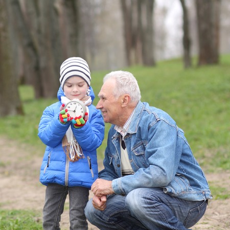 Grandfather and grandson study time on the old clockの写真素材