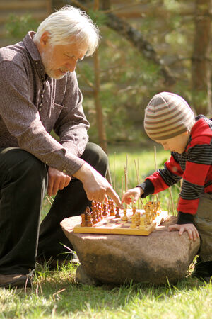 Grandfather and grandson playing chessの写真素材