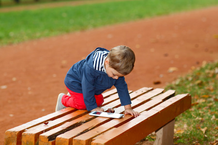 child with the tablet on benchの写真素材