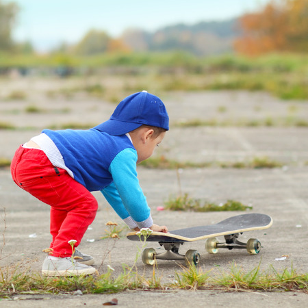 little boy having fun with skateboard outdoors.の写真素材