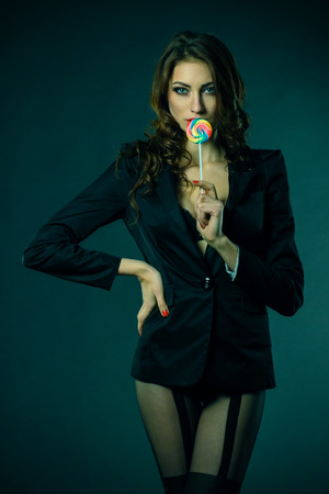 sexy girl in a jacket, stockings and bra sucks a lollipopの写真素材