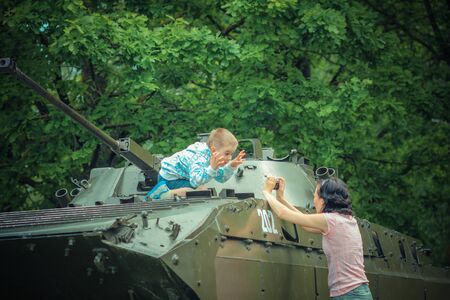 Mom takes pictures of his son on vintage military vehicle.の写真素材