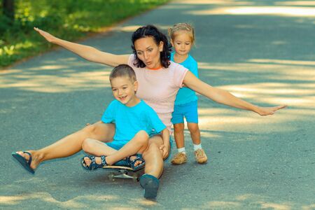 Family fun with skateboard. Little kids ride on a skateboard momの写真素材