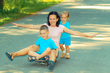 Family fun with skateboard. Little kids ride on a skateboard momの写真素材