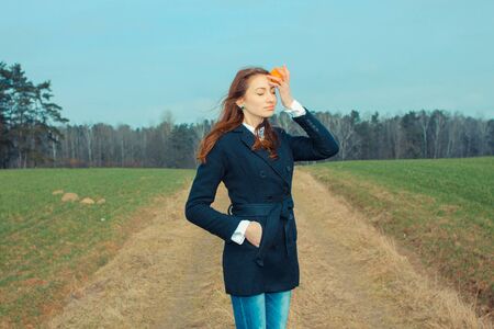 Girl with an orange fruit outdoors. conceptual photo. Fruit, as an example of a healthy diet.