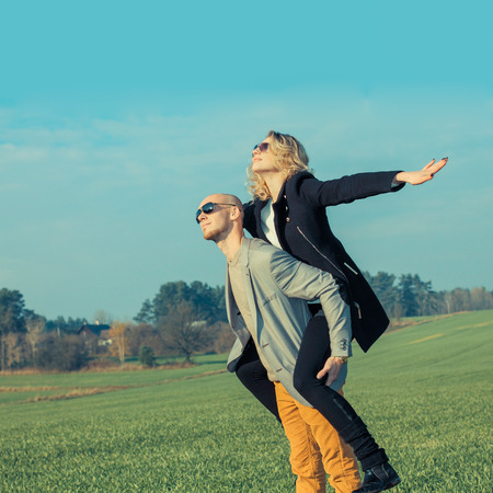 The couple has emotional and crazy fun outdoors. young beautiful couple having fun outdoors. Young happy couple outdoor portrait.の写真素材