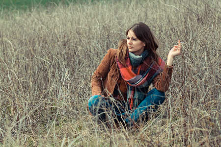 portrait of a beautiful hipster girl smoking outdoorsの写真素材