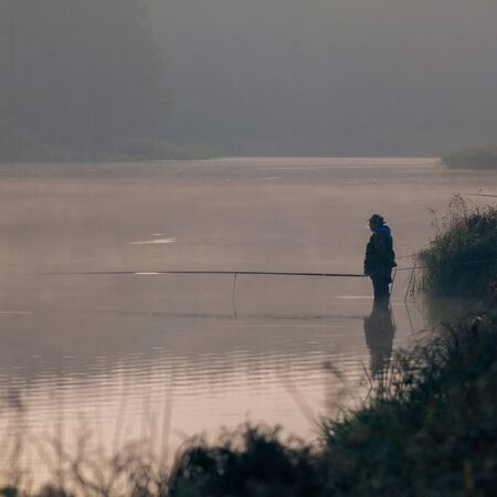 Fisherman fishing. A fisherman catches a fish in the morningの写真素材