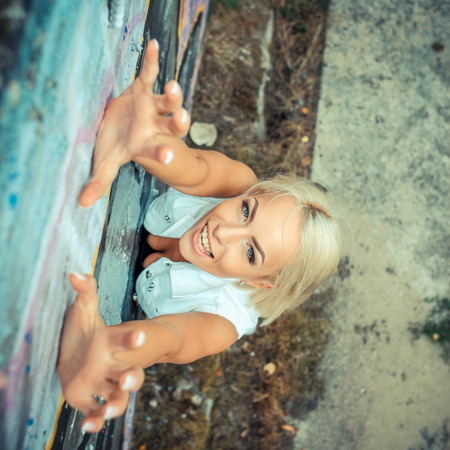 Positive hipster girl. portrait of a beautiful young hipster girl which climbs upwards. view from aboveの写真素材