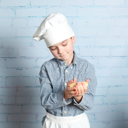 Little boy preparing dough for bread. Cute little boy in the kitchen preparing cookies. child chefの写真素材