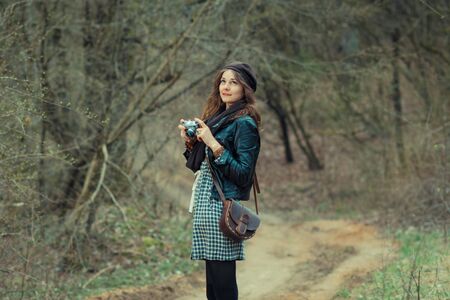 Hipster girl filming in the woods on a vintage movie cameraの写真素材