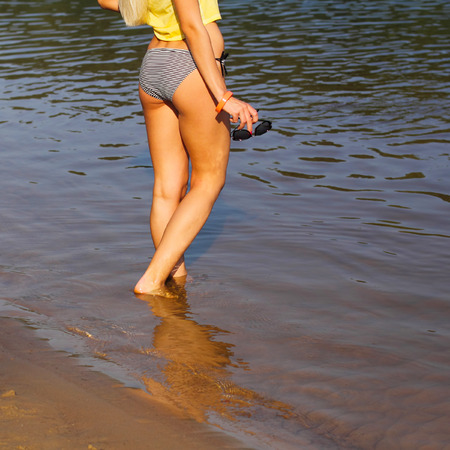 Woman walking on the beach. Beautiful woman legs, walking on the beach. Beautiful female legs go...