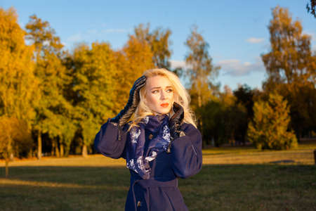sad woman with a headache outdoors in autumnの写真素材