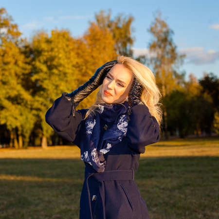 sad woman with a headache outdoors in autumnの写真素材